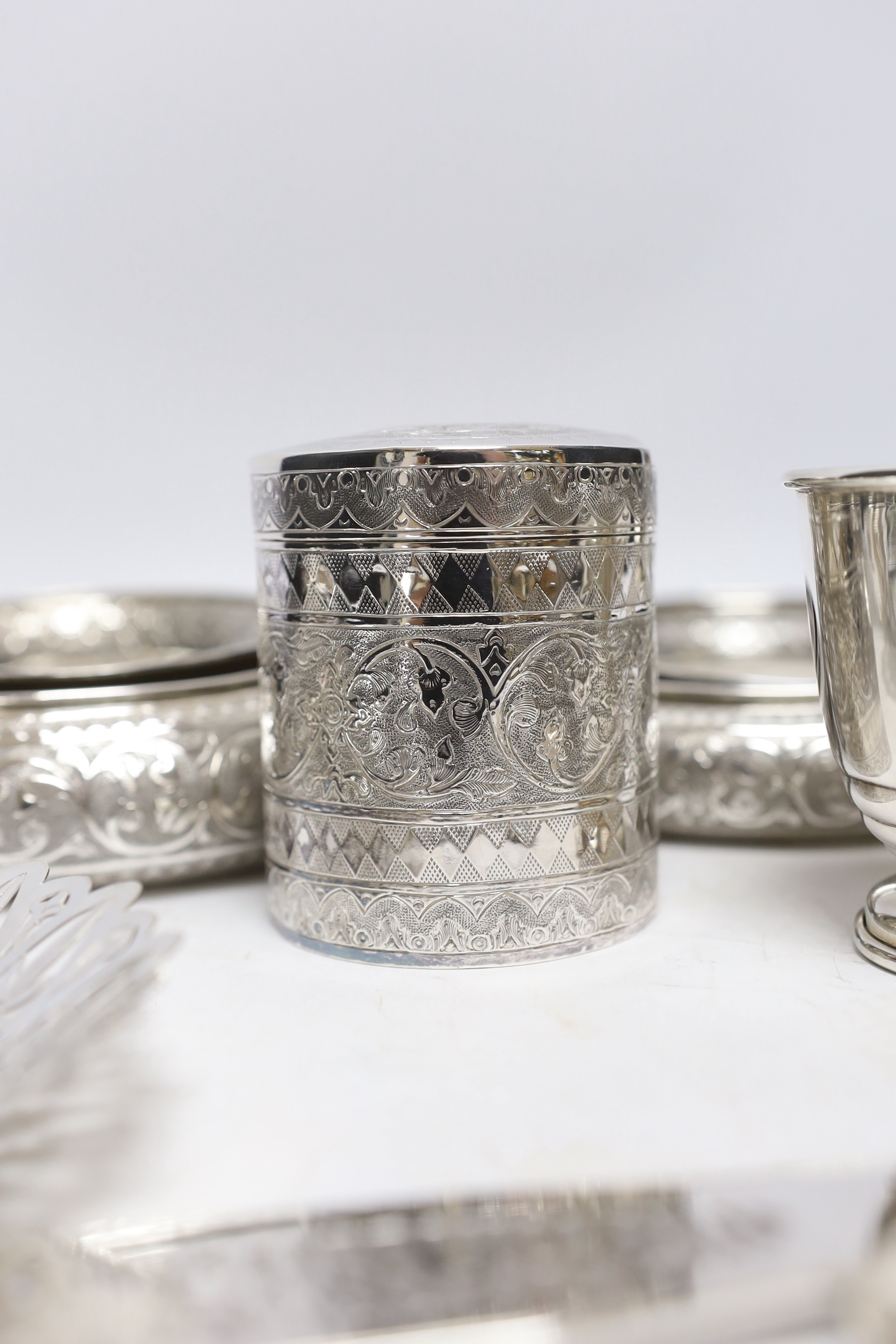 A group of silver and a white metal items including two Middle Eastern ring vases, two foliate dishes, a vase and a canister, together with a silver christening mug, 800 standard beaker, silver fish slice, two mounted gl